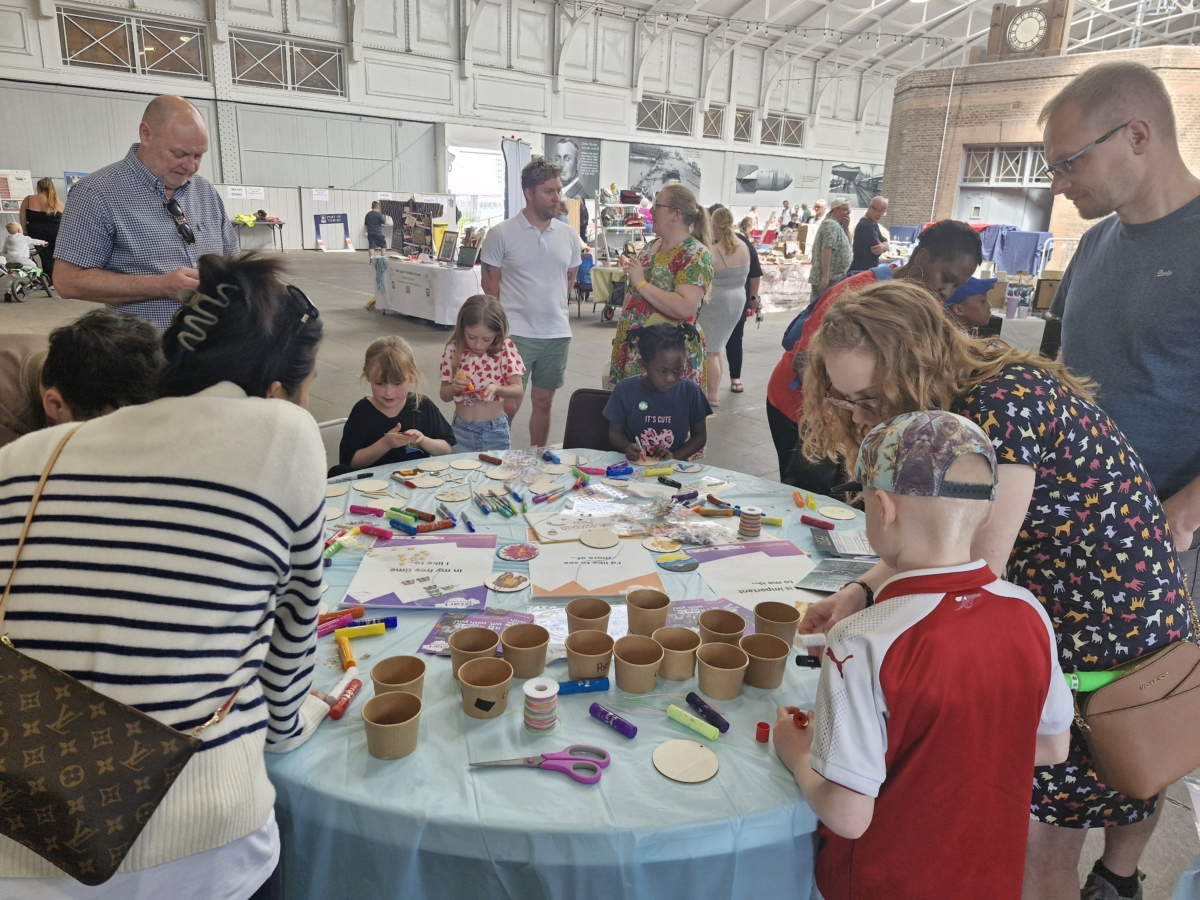 Children and adults around a table painting at the Port of Tilbury